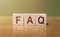 Faqs concept with wooden block on wooden table background