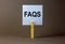 FAQS, frequently asked questions symbol. White paper on wooden clothespin. Words `FAQS, frequently asked questions`. Beautiful