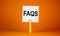 FAQS, frequently asked questions symbol. White paper on wooden clothespin. Words `FAQS, frequently asked questions`. Beautiful