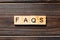 Faqs word written on wood block. faqs text on table, concept