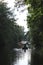 Far away river with trees on both coasts and rowing boats