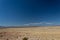 Far off view of distant mountains seen from across a vast desert plateau, deep blue sky, New Mexico USA