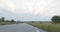 Far view of young couple of teens skateboarding and having fun on road