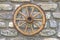 Far west wagon wheel on stone wall