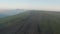 Faraway view of cars and people running and walking on plateau Bermamyth during dawn. Surface is covered with clouds.