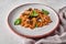Farfalle with eggplant, tomato sauce, parmesan and basil on plate with napkin