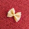 Farfalle Pasta Closeup on red textile background