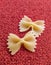 Farfalle Pasta Closeup on red textile background