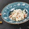 Farfalle pasta in a creamy cheese sauce in plate on dark stone background. Top view, Flat lay. Vegetarian food