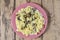 Farfalle pasta in a creamy sauce with champignon mushrooms in a plate on a wooden table.