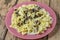 Farfalle pasta in a creamy sauce with mushrooms in a plate on a wooden table.