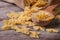 Farfalle pasta macro dry on a wooden spoon and an old table