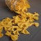 Farfalle pasta is randomly scattered on a wooden board