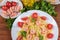 Farfalle pasta with shrimps and tomatoes among ingredients, top view