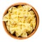 Farfalle pasta in wooden bowl over white