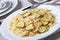 Farfalle pasta with zucchini slices closeup with a fork