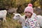 Farm animal. Cute little girl hugging goatling on pasture