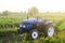 A farm blue tractor stands on the field. The use of machines in agriculture increases the speed and efficiency of work. Farming