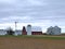 Farm buildings with active windmill on a cloudy day in Minnesota