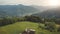 Farm buildings at mountain village aerial. Tractor at cottages. Countryside nobody nature landscape