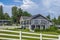 Farm country house in the field with fence. Countryside of Canada. Rural Farmhouse with barns on a sunny day in summer