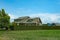 Farm country house in green field. Countryside of Canada. Rural Farmhouse with barns on a sunny day in a summer