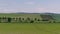 Farm green fields landscape with rural houses, blue sky