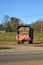 A farm hay wagon filled with silage waiting on the edge of a farm field