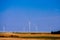 Farm landscape. Windmills operate in desert field. Clear sky, warm Sunny day