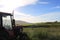 Farm meadows with tractor, grass and blue skies