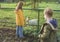 In the farm park with pets, children watch a goat. Boy and girl get acquainted with pets