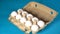 Farm raw, fresh white chicken egg in an egg box on a blue background. Eggs in carton. Eggs in the basket. Concept: a fresh egg for