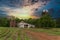 Farm with silos and dirt roat with crops