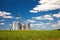 Farm tin silos storage towers in greenw crops view