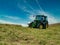 A farm tractor carrying out silaging operations on the Llyn Peninsula, Gwynedd, Wales, UK