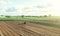 A farm tractor cultivates the soil in the field after harvest. Development of agricultural technologies. Loosening, improving soil