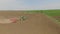 Farm tractor handles earth on field, drone video