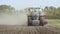 Farm tractor moving on agricultural field. Agricultural equipment