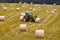 Farm tractor moving hay bales