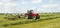 A farm tractor raking hay silage in field