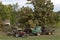 Farm tractor vehicles under tree at forest farm house