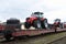 Farm tractors loaded on a freight train and delivered by rail from factory in the customs control zone for for customer delivery.