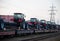 Farm tractors loaded on a freight train and delivered by rail from factory in the customs control zone for for customer delivery.
