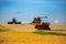 Farm vehicles at work in crop field