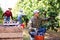 Farm worker gathering harvest of plums in green orchard