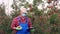 Farmer, agronomist, in protective mask, inspects apple harvest to avoid pests, checks the ripeness of fruit. makes notes