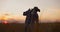 Farmer agronomist walking through ripe wheat field at sunset.Worker holding shovel touching spikes