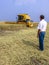 Farmer analyzing worl of combine harvester