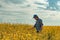 Farmer in blooming canola field