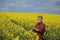 Farmer in blossoming oilseed field in spring